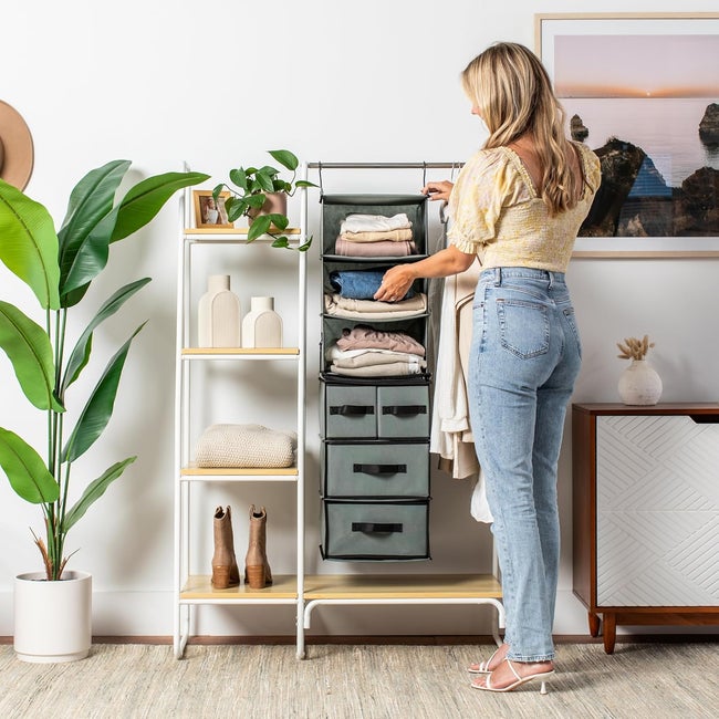Person organizing clothes in a hanging closet organizer