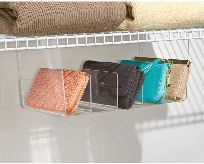 Clear acrylic wallet organizer on a shelf holding various wallets