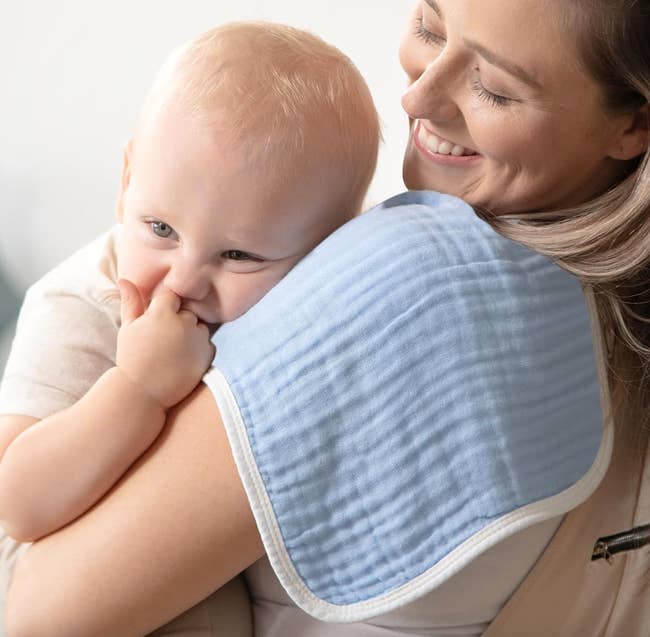 a exemplary holding a babe with a burp cloth implicit their shoulder