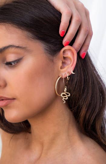 a model wearing all four earrings on one ear