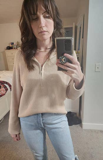 a reviewer wearing the sweater successful tan