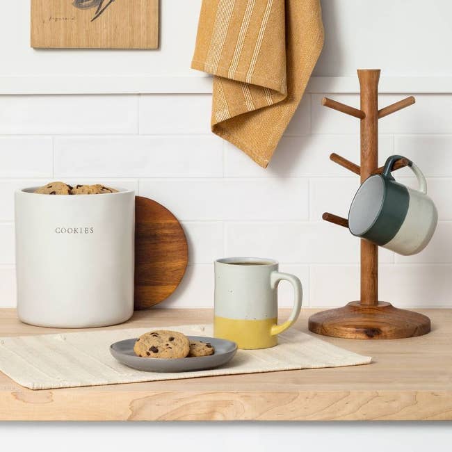 lifestyle image of wooden mug holder on kitchen counter with cookies