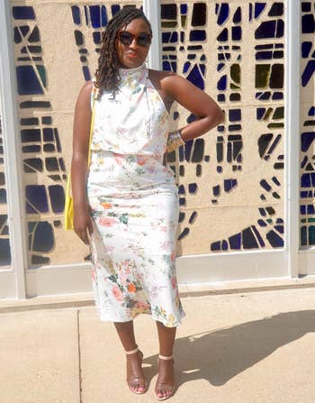 Person successful  a floral halter formal  and sunglasses stands confidently successful  beforehand   of an abstract-patterned wall