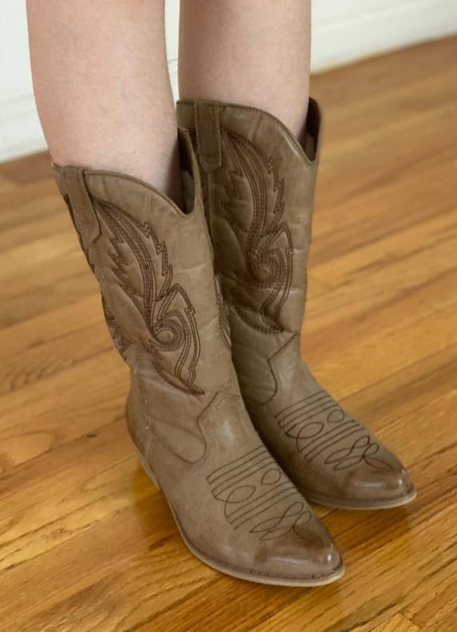 a reviewer wearing the cow boy boots in light brown 