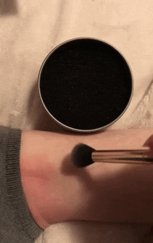 gif showing a reviewer rubbing an eyeshadow brush leaving pigment on an arm, then cleaned in the sponge for a few seconds, then wiped again on the arm showing no makeup is left on it