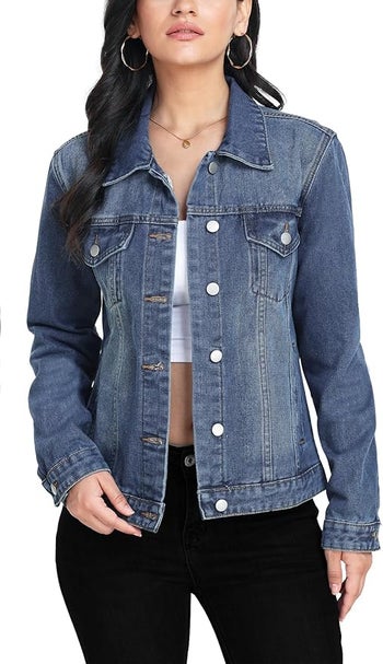 Model showcasing a denim jacket with button closure and flap pockets, paired with a white high