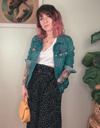 another reviewer wearing the black skirt styled with a denim jacket and handbag