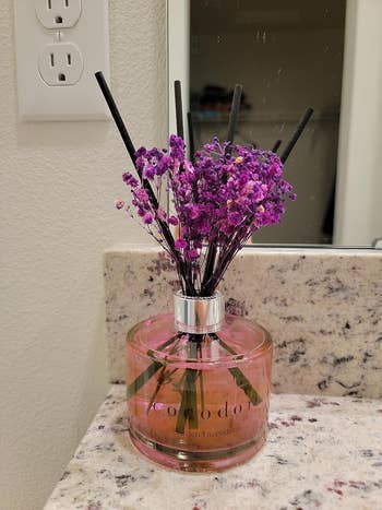 A reed diffuser with lavender scent in a clear bottle