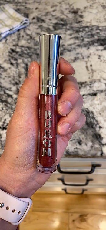 a reviewer holding the lip plumper