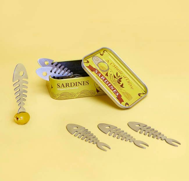 Decorative sardines-themed tin with metal two-pronged fish forks