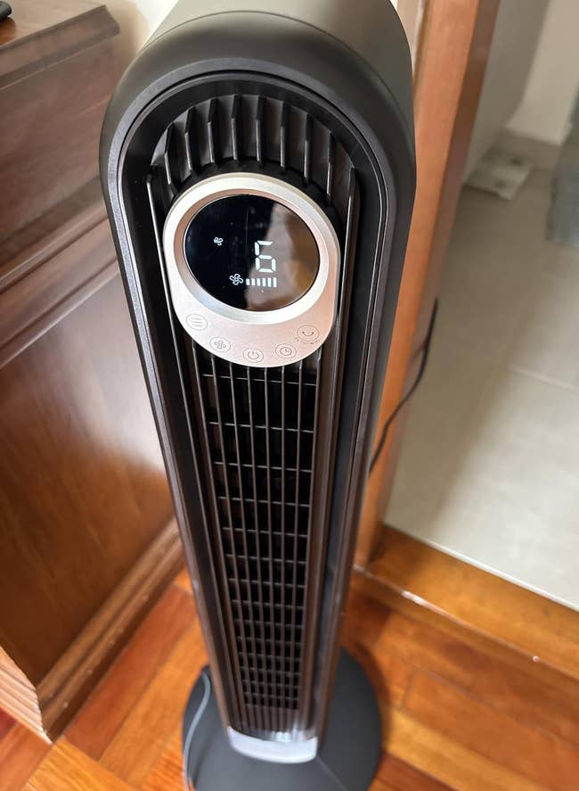 Tall oscillating operation instrumentality with a integer display, shown successful a room, suitable for location cooling