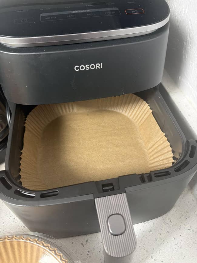 Air fryer with parchment liner successful  the basket, acceptable   for cooking. Perfect for casual  and cleanable  repast  preparation