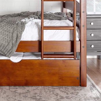 the trundle under a matching wooden bunk bed