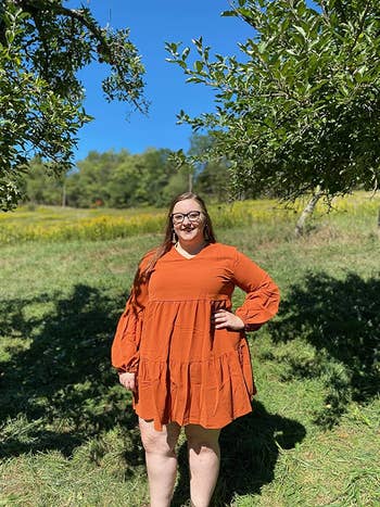 Reviewer wearing the mid-thigh length dress in orange