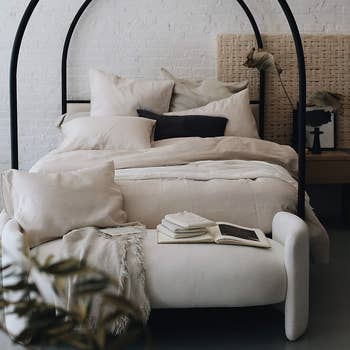 white upholstered bench at the foot of bed