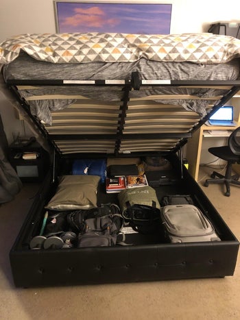 the same reviewer showing the bed pulled up, revealing all the storage underneath