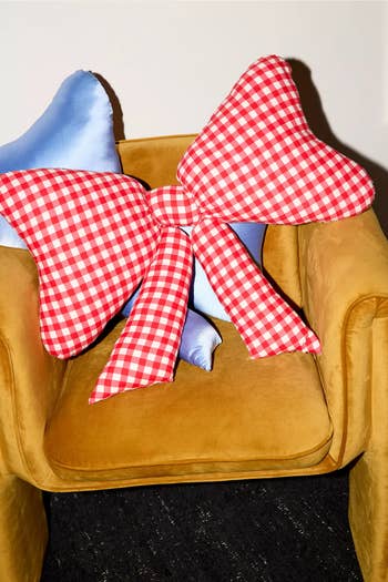 Gingham checkered bow-shaped pillow on a plush armchair, highlighting a decorative home accessory