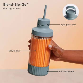 Hand holding a spill-proof, easy-grip blender bottle with a straw, labeled 