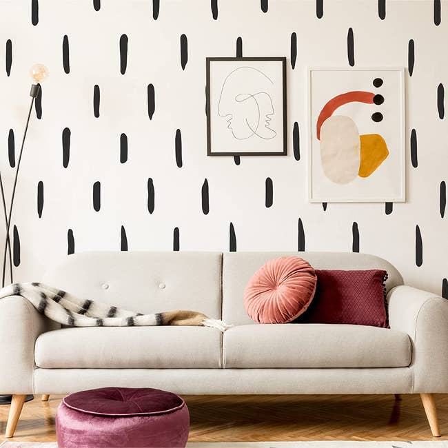 the decals on a wall behind a gray couch