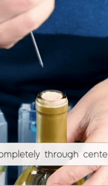 Model piercing a bottle with a thin needle that uses pressurized air to pop the cork off 