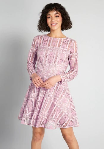 front of a model wearing the pink lace mini dress