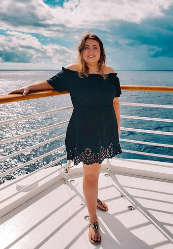 reviewer wearing theblack dress on a boat