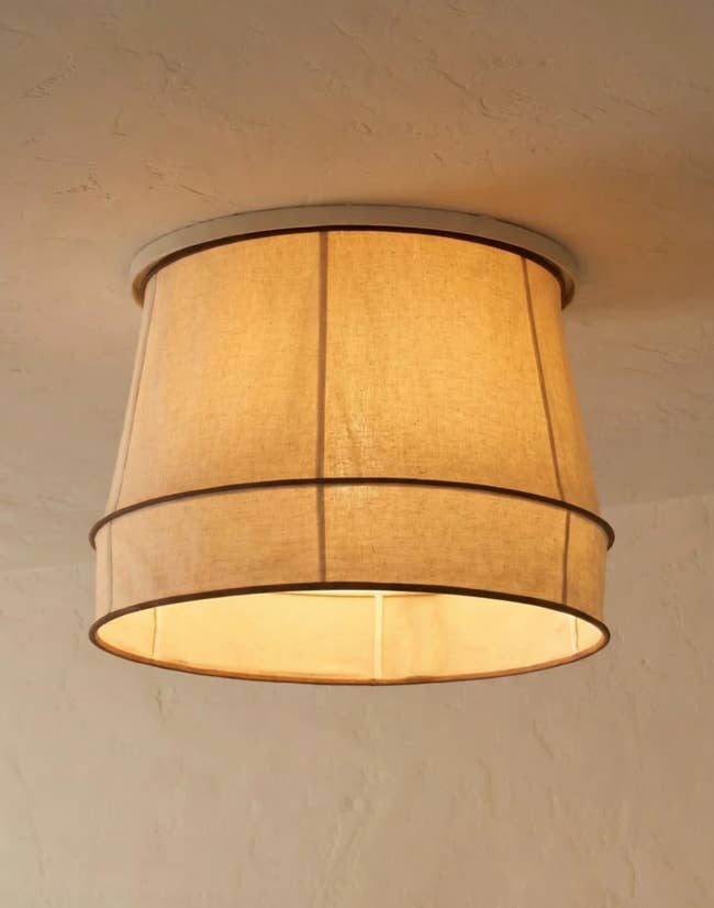 Fabric drum ceiling airy  fixture hanging from a achromatic  ceiling, suitable for modern   location  decor