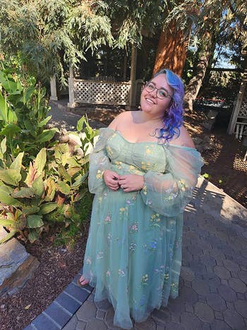 a reviewer in a long tulle dress with embroidered flowers on it