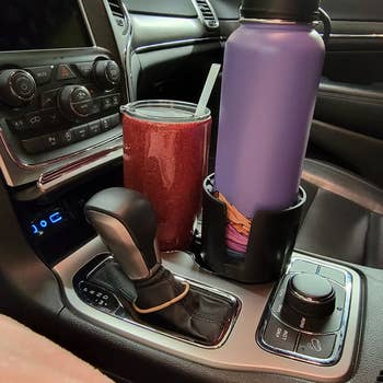 reviewer image of the expander with a water bottle in it and a coffee cup int eh cup holder next to it
