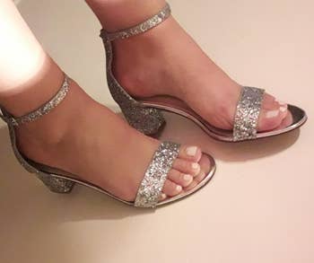 Close-up of sparkly heeled sandals on reviewer's feet