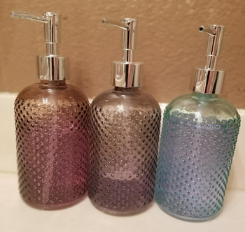 Reviewer image of three different colored soap dispensers 