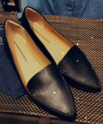 a reviewer photo of a pair of black pointed-toe loafers 