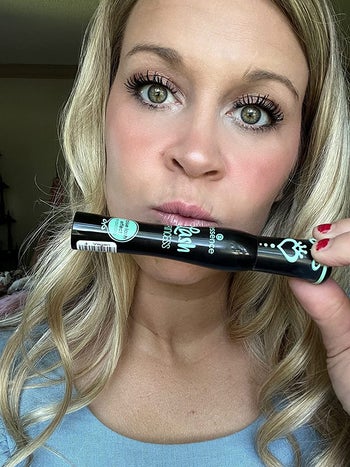 image of reviewer with full, dark lashes as they hold up the essence lash mascara