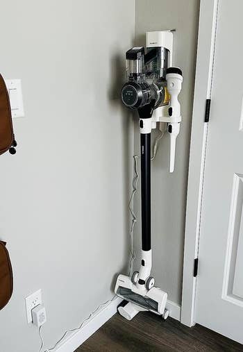a reviewer photo of the vacuum hung on the included wall mount