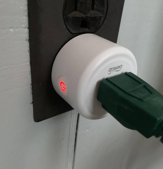 a reviewer photo of a smart outlet plugged into a wall socket 