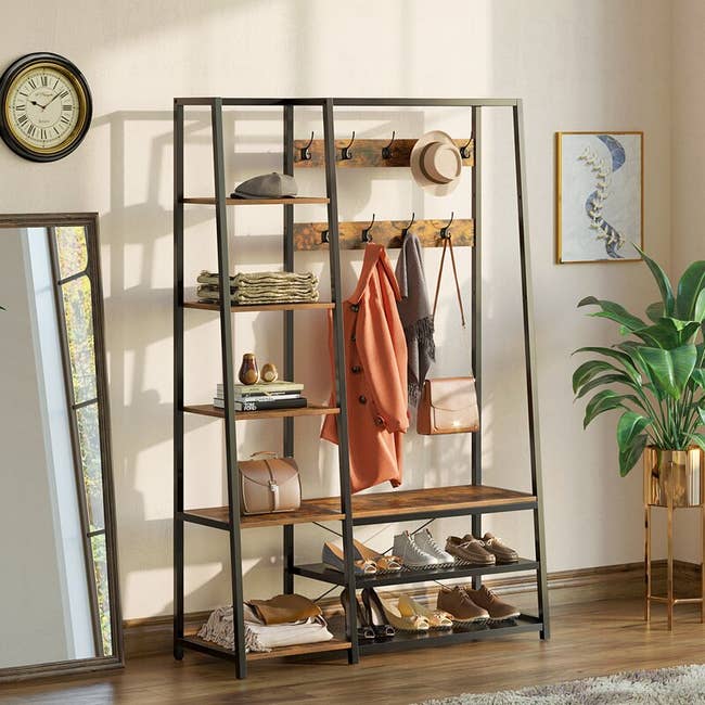 the hallway organizer with shoes on the shelves, jackets hanging, purse and other decorative items 
