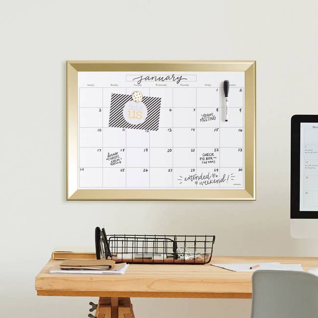 a product image of the calendar hanging over the desk with writing and magnets holding notes onto it