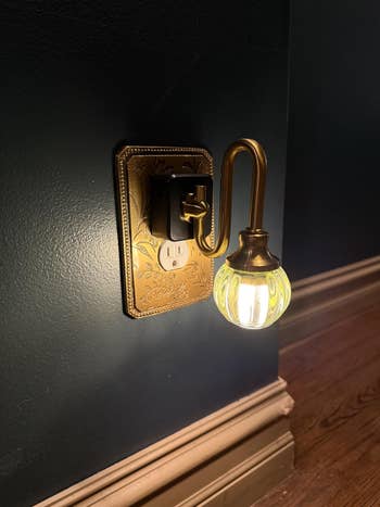 Decorative brass nighttime airy with an ornate plan and vintage-style bulb plugged into a partition outlet
