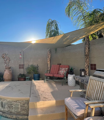 reviewer's shade triangle above a seated area by the pool