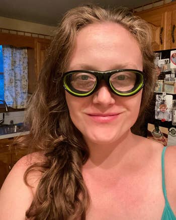 reviewer taking a selfie and showing the black and green onion goggles