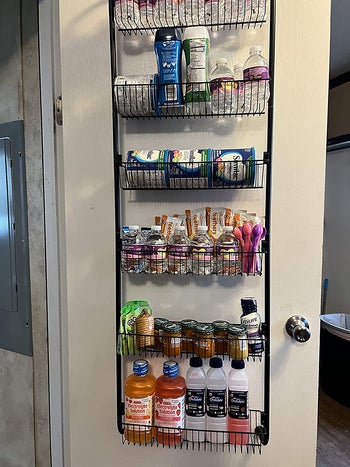 Reviewer photo of various baby food products in over-the-door pantry organizer