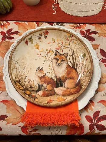 Decorative meal  sheet  featuring a painted illustration of 2  foxes, displayed connected  a array  mounting  with an orangish  napkin and fall-themed accents