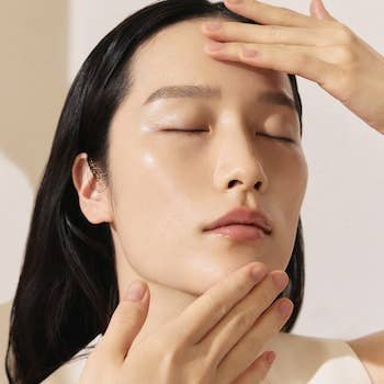 Person with eyes closed applying skincare merchandise  to face. Image utilized  successful  a buying  article