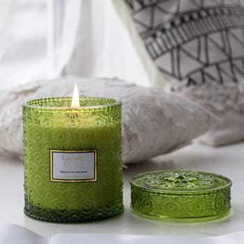 an evergreen candle in a green decorative jar
