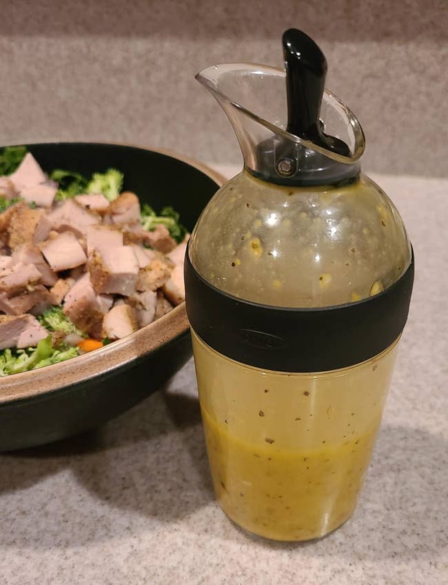 Salad with chopped chickenhearted and broccoli is served adjacent to a transparent dressing instrumentality with a achromatic spout connected a countertop