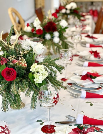 a beautiful holiday table with red santa hat silverware holders