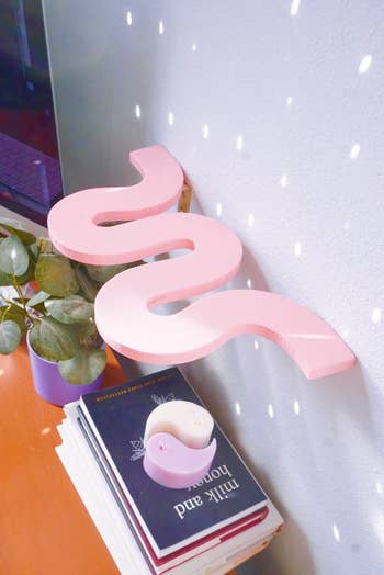 pink squiggle shelf hung on a wall