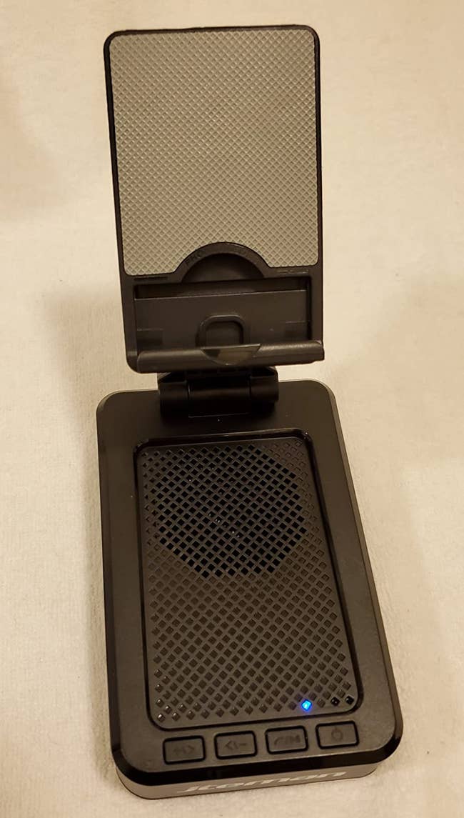 reviewer photo of a black bluetooth speaker with a built-in phone stand