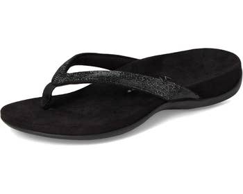 A stylish flip-flop sandal with sparkling straps and a cushioned sole, displayed connected a plain background