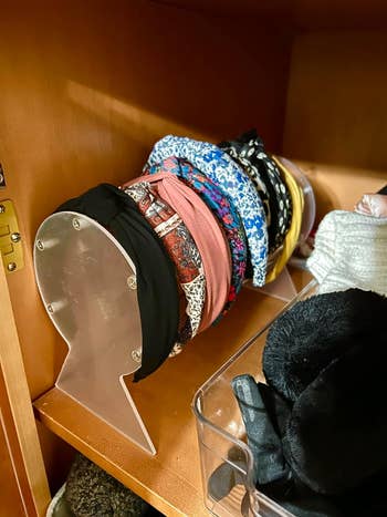 A stack of various headbands on a clear acrylic holder